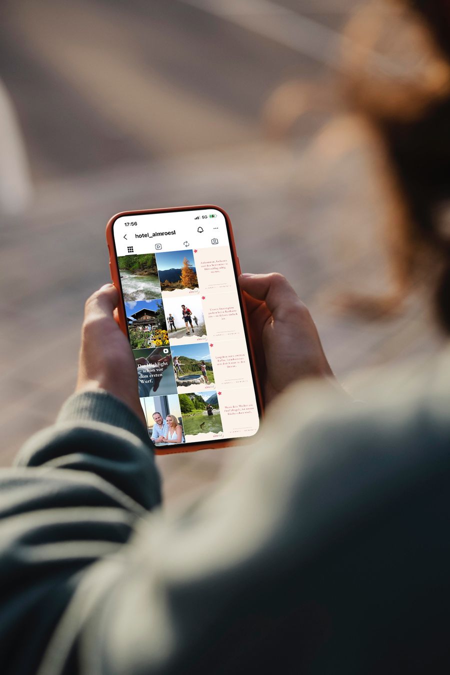 Smartphone mit dem Instagram-Profil eines ContentOS-Hotelkunden: Feed mit einheitlich gestalteten Bild- und Textbeiträgen